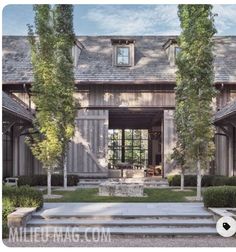 the front entrance of a house with steps leading up to it and trees on either side