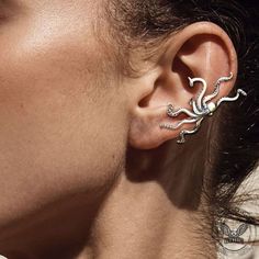 a close up of a person with ear piercings on their ears and behind them is a woman's head