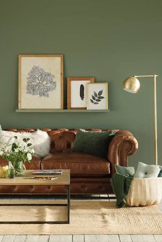 a living room with green walls and leather furniture