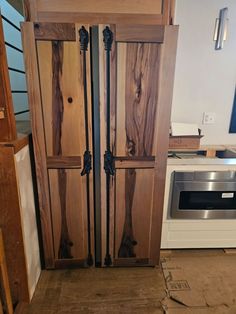 a kitchen with an oven, microwave and cupboards made out of wooden planks