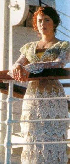 a woman is standing on the deck of a ship and looking off into the distance