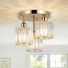 a chandelier hanging from the ceiling in a room with white walls and windows