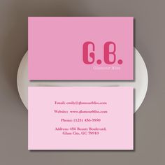 a pink business card with the letter c b on it and a white plate underneath