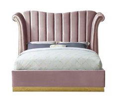 a bed with a pink velvet headboard and foot board