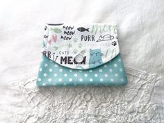 This adorable white and turquoise cat mini wallet is the right size for your pocket, small purse, or backpack.  The style is perfect for everyday use or traveling.  It measures 4 1/2 inches in width (at widest part) by 3 1/2 inches.  The small wallet has 3 sections inside which are perfect size for you driver's license, credit card, gift cards, cash (folded in half), and more.  The wallet is sewn on a machine and has a layer of batting between the fabric.  It has a pearl snap which is functional and decorative.  The snap can be a little stiff at first, but loosens up with use. This would be a great gift, or perfect for your own use. White cat fabric with turquoise polka dot lining.  PLEASE NOTE:  Placement of cat design may vary due to fabric and pattern layout. Please check out my other s Cute Cat Design Coin Purse For Everyday Use, Cute Cat Design Coin Purse For Everyday, Cute Everyday Cat Design Coin Purse, Pattern Layout, Purse Backpack, Cat Fabric, Button Jewelry, Card Gift, Mini Wallet