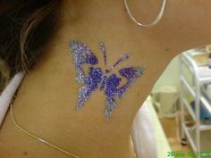 the back of a woman's neck with purple glitter butterflies on her left side