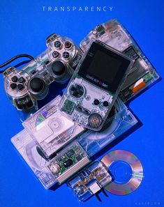 an electronic device sitting on top of a blue surface next to two cd's