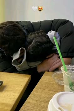 a man sleeping on top of a couch next to a cup