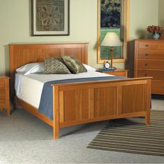 a bedroom with a bed, dressers and mirror in it's center area