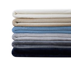 four folded blankets stacked on top of each other in various colors and sizes, with one folded