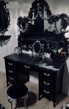 an ornate black vanity with mirror and stool