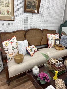 a living room filled with lots of furniture next to a wall covered in pictures and paintings