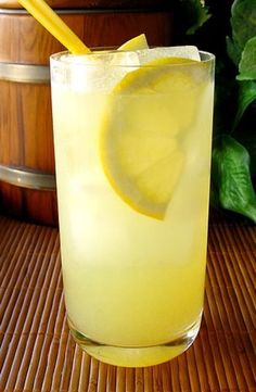 a glass filled with lemonade sitting on top of a table