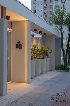 the entrance to an office building with planters and lights on it's sides