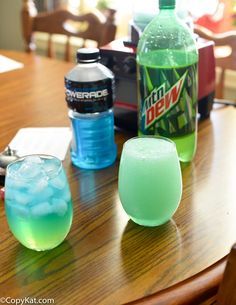 there are two drinks on the table and one is green