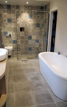 a bathroom with a tub, sink and shower in it's center wall is shown