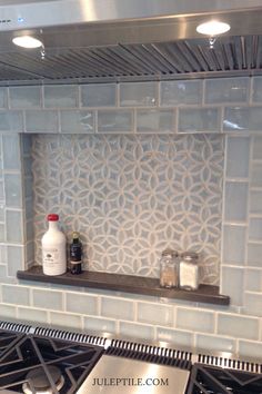 a stove top oven sitting inside of a kitchen next to a counter with a bottle on it