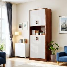 a living room with two blue chairs and a white cabinet in front of a window