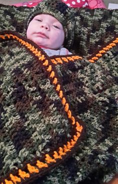 a baby wrapped up in a crocheted blanket