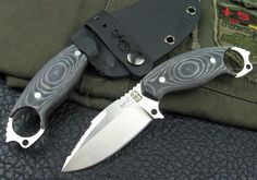 two knives sitting next to each other on top of a black cloth covered tablecloth