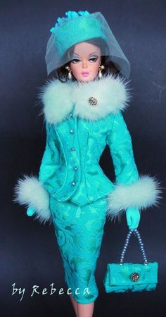 a barbie doll wearing a blue dress and hat with fur trimmings, holding a purse