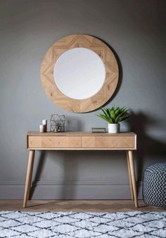 a wooden table with a mirror on it and a potted plant in front of it