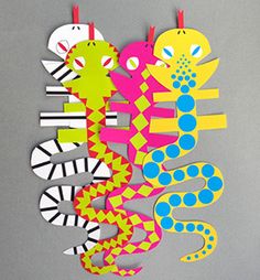 some cut out paper animals on a gray surface