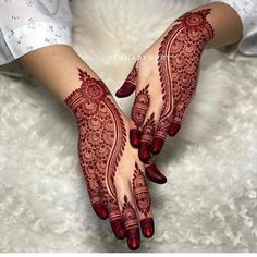 a woman's hands with henna tattoos on them