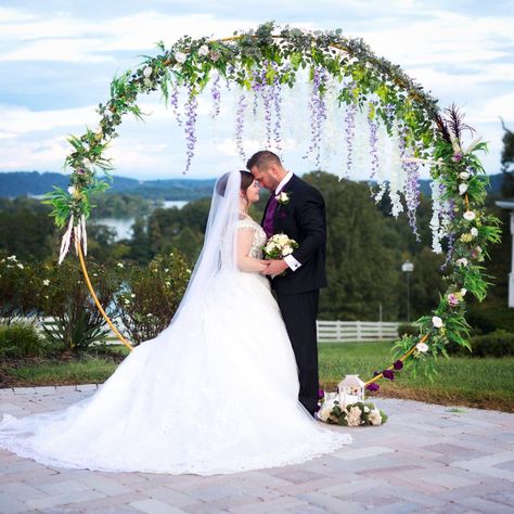 This floral photo backdrop arch was decked in silk ferns, eucalyptus, garden roses, purple and white wisteria, feather and pampas grass, made by yours truly. Purple Floral Arch, Purple Flower Arch Wedding, Wisteria Arch Wedding, Wisteria Wedding Arch, Wisteria Wedding Colors, Wisteria Wedding Decor, Wisteria Backdrop, Purple Wedding Arch, Photo Backdrop Arch