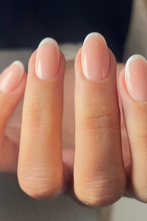 Timeless elegance in a manicure! The nails are crafted with a soft almond shape, featuring a classic French tip that's flawlessly executed with crisp white borders. The nude base complements the white perfectly, creating a sleek and sophisticated look suitable for any occasion. Perfect for those who appreciate a chic, refined style.  // Photo Credit: Instagram @nailhousebydiana Classic Short Almond Nails, Classic Squoval Nails, Neutral Nails Engagement, French Nails Ideas Oval, French Tip Gel Manicure Natural Nails, French Classic Nails, Clear Wedding Nails, Neutral Color French Tip Nails, French American Nails Natural