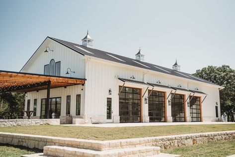 On east facade of Green Barn, add the 3 new rooms, plus an extended shade area. Can we add any decorative elements to roof line? Add plant-n faux hay door on east and west facades near roofline apex? Use exterior lamps and possible small overhangs on south facade such as shown on this photo? Venue With Garage Doors, Wedding Venue With Garage Doors, Event Venue Buildings, Wedding Venue Farmhouse, Barn Wedding Furniture, Wedding Venue Buildings, Winery Ideas Decor, Wedding Venues Exterior, Barndominium Event Center