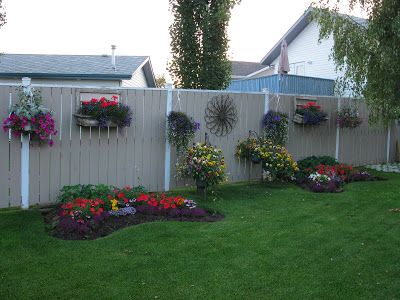 Outside Fence Painting Ideas, White Fence Decorating Ideas, Painted Fence Posts, Fence Hanging Planters, Painted Fence, Backyard Fence Decor, White Fence, Fence Landscaping, Fence Decor