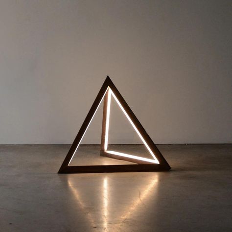 Like a monolithic force rising from the ground, Tetra abstracts the iconic form of the pyramid into a compact standing lamp. Graphic lines of light meditate on the strength of this prismatic shape. Solid wood softens and elevates Tetra into a diminutive statement piece, standing just shy of TK-inches. Features Country of Origin: Canada Suitable for indoor use Available in various wood finishes Wooden Lamps Design, Wood Lamp Design, Wooden Light, White Floor Lamp, Black Floor Lamp, Wooden Lamp, Wood Lamps, Design Light, Standing Lamp