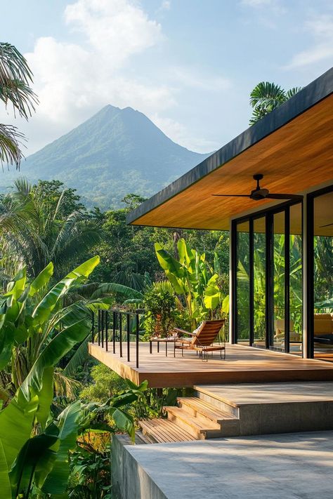 Wooden deck with lounge chair overlooking lush greenery and mountains. Here’s how tropical minimalist houses blend simplicity with vacation vibes, effortlessly creating that paradise-found feeling right at home. Minimalist Houses, Tropical Minimalist, Modern Residential Architecture, Wooden Deck, House Blend, Vacation Vibes, Paradise Found, Wooden Decks, Tropical Houses