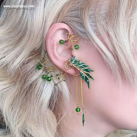 Embrace the enchanting allure of the forest with our "Verdant Aurëlinn" Elven Ear Wrap Earring, part of the Elvenwood Blossoms Collection. Crafted with meticulous attention to detail, this exquisite earpiece captures the essence of Elvish elegance. Handcrafted from non-tarnish gold-plated wire, each intricate twist and curve of the design reflects the graceful beauty of nature. Adorned with shimmering Swarovski crystals and delicately cast resin leaves, this ear wrap gleams with a mesmerizing ch Elvish Jewelry, Ear Wrap Earrings, Gold Leaf Design, Elf Ear Cuff, Fantasy Earrings, Fairy Ears, Elven Jewelry, Wrap Earrings, Woodland Fairy