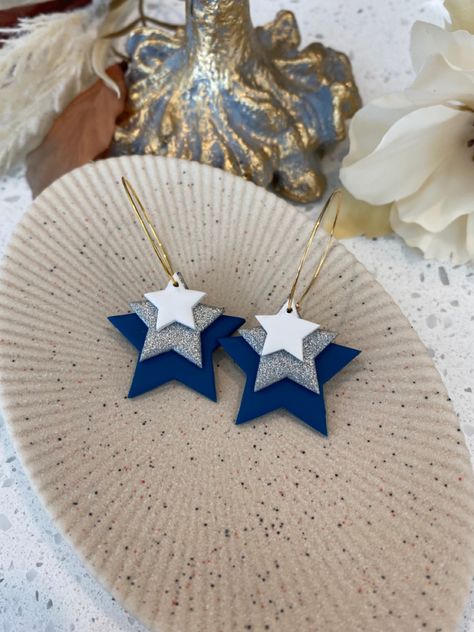 Gold hoops with a large navy blue star, a medium sized silver star, and a small white star attached. Dallas Cowboys Clay Earrings, Dallas Cowboy Cheerleader, Cowboy Cheerleaders, Polymer Clay Kunst, Dallas Cowboys Star, Star Hoop Earrings, Football Earrings, Diy Earrings Polymer Clay, Pom Pom Girl