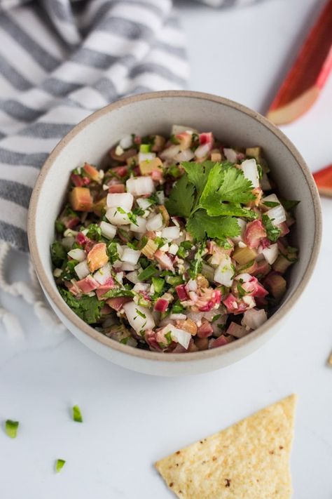 A bowl of spicy rhubarb salsa with a towel in the background and tortilla chips scattered nearby Rhubarb Salsa Recipe, Rhubarb Salsa, Blueberry Rhubarb, Rhubarb Muffins, Salsa Sauce, Salmon Tacos, Sour Taste, Rhubarb Recipes, Garden Recipes