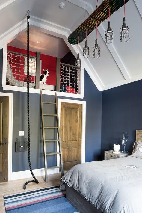 Blue and red boy's bedroom boasts a blue striped rug placed in front of a wood bed dressed in gray bedding lit by linear cage chandelier hung from a white panel vaulted ceiling. Turquoise Teen Bedroom, Red Boys Bedroom, Vaulted Ceiling Bedroom, Boys Room Blue, Magical Furniture, Teen Bedroom Designs, Teen Boy Bedroom, Blue Furniture, Cottage Bedroom