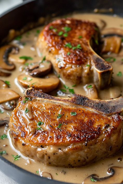 These smothered pork chops with mushroom gravy are such a hearty treat! This one-pan meal is sure to please the entire family. Mushrooms And Pork Chops, Pork Steaks And Gravy, Pork With Mushroom Sauce, Smoothed Pork Chops, Pork Chops With Brown Gravy, Smother Pork Chops, Pork Chops With Mushroom Soup, Pork Chop Meals, Pork Chops In Mushroom Gravy