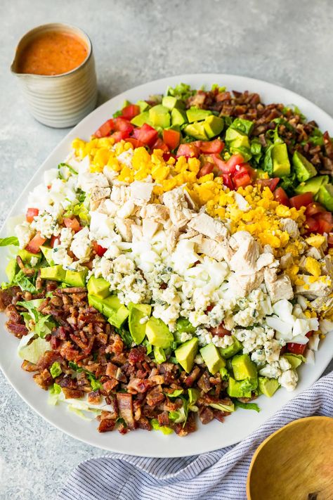 Layers of hard boiled eggs, bacon, blue cheese, tomatoes and avocado make up this classic Cobb salad recipe. It's the perfect lunch salad! #saladrecipe #healthyfood #easyrecipes #healthyeating #mealprep Cobb Salad Board, Bacon Egg Salad Recipe, Egg Salad Recipe With Bacon, Classic Cobb Salad Recipe, Big Salads, Bacon Egg Salad, Classic Cobb Salad, Cobb Salad Recipe, Lunch Salad