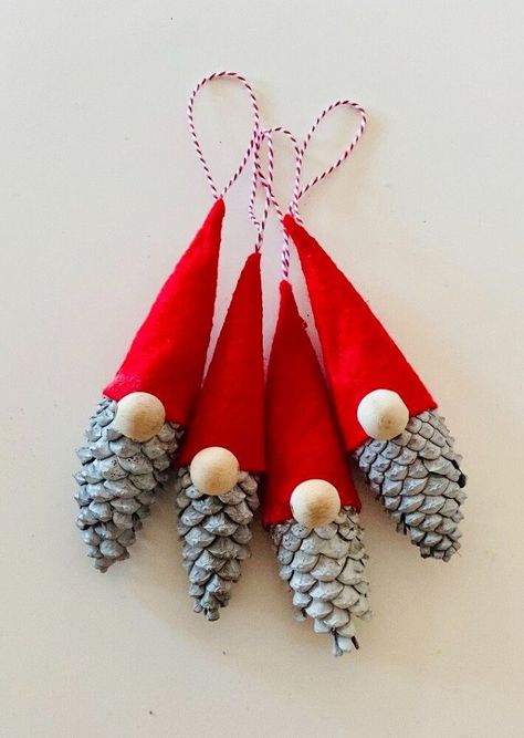 Make these adorable christmas gnomes in minutes using pine cones. If you like these cute gnomes, let me show you how to make them. Step 1 collecting pine conesI selected a variety of pine cones, I tried to pick up the big ones. Step 2 painting the pine conesI used white spray paint to color my pine cones and left them dry. Step 3 making the hat I used red felt fabric for the hat. I cut a small piece of felt that is like a quarter of a circle. Step 4 the hat I gave the felt… Gnome Pine Cones, Xmas Cones Decorations, Pine Cone Gonk, Diy Pine Cone Gnomes, Pine Cone Gnomes Diy How To Make, Christmas Decor Ideas Pine Cones, Diy Christmas Sprays And Picks, Pine Cone Santa, Fir Cone Crafts