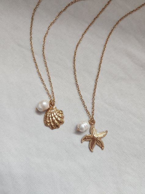 -seaside girl necklace- miss the ocean? bring a little of it with you with this coastal-themed necklace! seaside girl starfish necklace: features a starfish charm, freshwater pearl charm, gold chain, lobster clasp, and extension chain. details:  - 38 cm without extension  - 43 cm with extension  - comfortable & durable  - handmade with love seaside girl shell necklace: features a shell charm, freshwater pearl charm, gold chain, lobster clasp, and extension chain. details:  - 38 cm without extension  - 43 cm with extension  - comfortable & durable  - handmade with love feel free to message me if you have any questions or concerns! Shell With Pearl Necklace, Shell Gold Necklace, Necklaces With Charms, Beach Themed Jewelry, Beach Jewelry Aesthetic, Gold Necklace Wedding, Dope Jewelry Accessories, Surf Jewelry, Preppy Jewelry