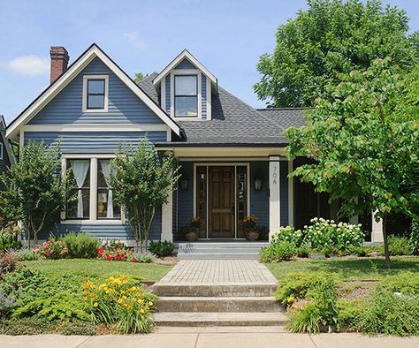 Blue is a universally beloved color that always delights. The calming and notable hue works especially well on homes situated in established neighborhoods or set on tree-lined streets. On this true-blue exterior, white-painted trim outlines roof peaks and windows; black paint highlights window sashes and dentil moldings running across window and door trim. White columns frame the front steps to direct traffic to the entry door. Exterior Color Combinations, Green Shutters, Brown Roof, Pintura Exterior, Exterior Color Schemes, Exterior Paint Colors For House, Casa Exterior, Country Blue, Painting Trim