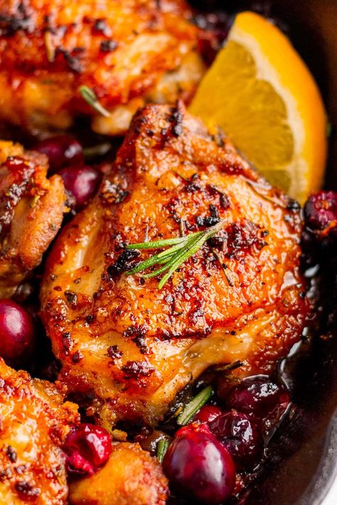 This cranberry chicken is chicken thighs roasted with fresh cranberries, orange juice and seasonings. A quick and easy dinner option that's great for a busy weeknight! Orange Cranberry Chicken Thighs, Baked Chicken Recipes Thanksgiving, Chicken Thigh Cranberry Recipes, Chicken Cranberry Wrap, Cranberry Orange Roasted Chicken, Apple & Cranberry Roasted Chicken, Chicken Christmas Dinner Ideas, Friendsgiving Chicken Recipes, Cranberry Roasted Chicken