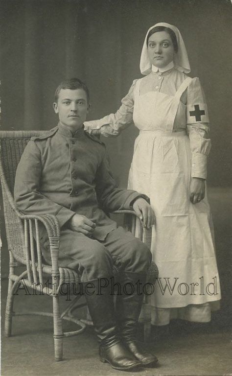 Vintage portrait of a nurse dressed in a high-collared pinstriped uniform with a pinafore and veil standing next to a seated soldier wearing a Great War uniform, watermarked Antique Photo World. Nurse And Soldier, Ww1 Nurse, Medical Clothing, Vintage Nursing, Red Cross Nurse, Tea Merchant, Nursing History, Vintage Nurse, Florence Nightingale