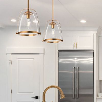 Full of bold mid-century modern style, this 1-light pendant showcases a sleek, mixed-material construction to illuminate your dining area, kitchen, or entryway. The delicate clear glass dome shade is suspended inside a sleek metal frame. It reflects the ambient glow of a 100W max bulb (sold separately). This pendant light hangs with the help of a height-adjustable downrod and is compatible with dimmer switches, allowing you to control the level of brightness in your space. | Wade Logan Ashiya 1 Brushed Gold Kitchen Light Fixtures, Clear Pendant Lights Over Kitchen Island, Mini Pendant Lights Over Kitchen Island, Pendant Lights Over Kitchen Island Gold, Brushed Gold Light Fixtures, Gold Pendant Lights Over Kitchen Island, Glass Kitchen Pendant Lights, Hanging Pendant Lights Kitchen, Clear Pendant Light