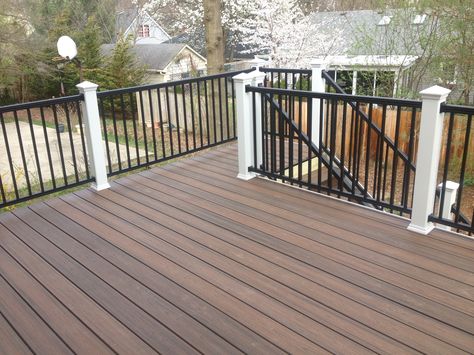 Trex spiced rum decking with white post sleeves, and black aluminum rails.  Look at the great color variation in the Tropical finish line of transcends from Trex. Colorful Patio, Deck Colors, Building A Porch, Trex Deck, Red Brick House, House Deck, Deck With Pergola, Iron Railing, Diy Deck