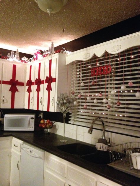 Red, white, black and silver Christmas in the kitchen. Rolls of red velvet ribbon and bows from the dollar store. A total of $12 did all 14 of my upper cupboards. Dollar Store Christmas Decorations, Lights Decorations, Christmas Decorations Apartment, Christmas Apartment, Dollar Store Christmas, Christmas Tablescape, Christmas Kitchen Decor, White Christmas Decor, Christmas Cactus