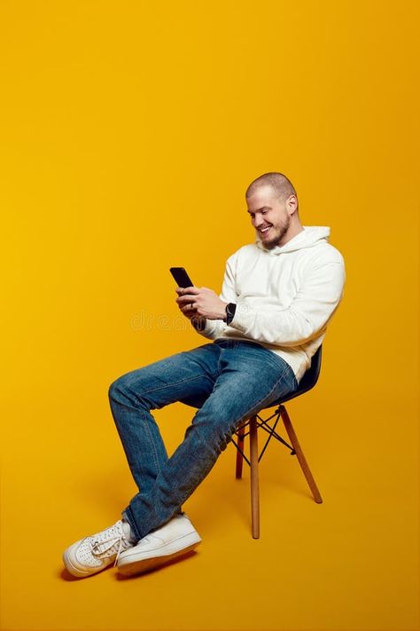 Happy student cute guy using smartphone while sitting on chair isolated on yellow background stock photos Guy Sitting In Chair, Cute Guy, Sitting Chair, Photos Background, Happy Students, Man Photography, Background Photo, Single Men, Art Model