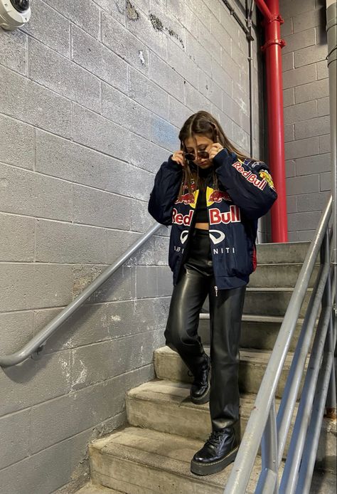 a girl walking down stairs wearing a racing jacket and leather pants Racer Jacket Mini Skirt Outfit, Trendy Fits Summer, Motor Cross Jacket Outfit, Racing Jacket Women Outfit, F1 Race Day Outfit For Women, Redbull Jacket Aesthetic, Racing Jacket Outfit Women, Formula 1 Women Outfit, Formula 1 Jacket Outfit